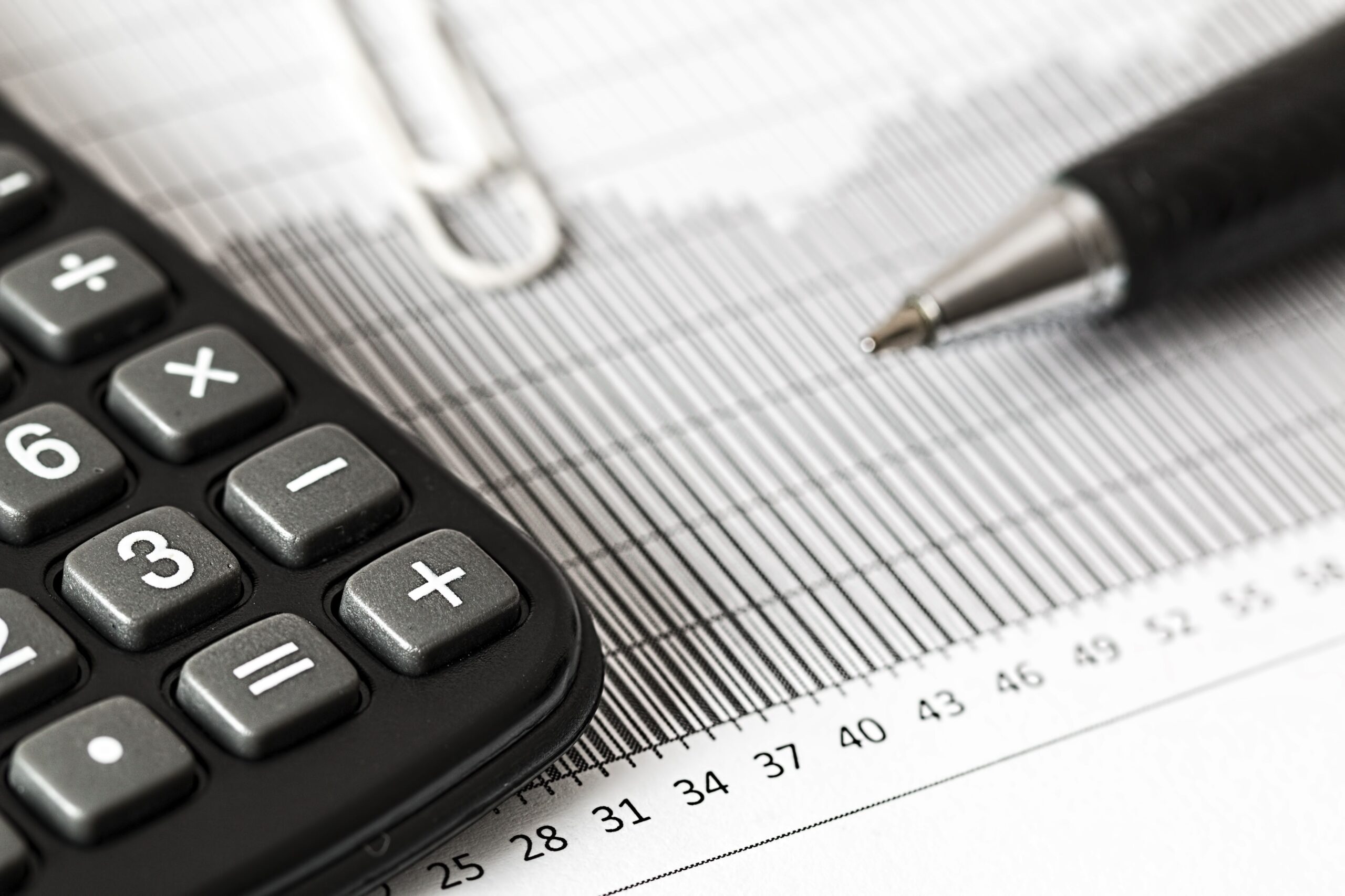 Calculadora y lapicera sobre el escritorio para calcular el costo laboral de un empleado