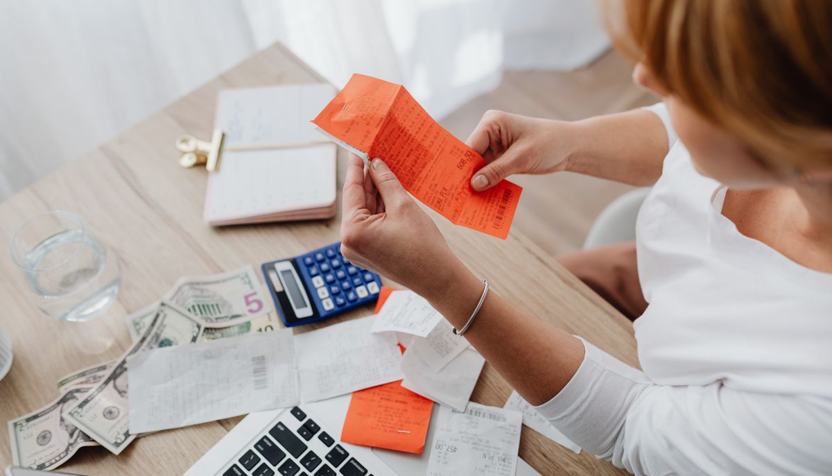Escritorio con calculadora, billetes y documentos, contexto de finanzas de un negocio y gastos personales